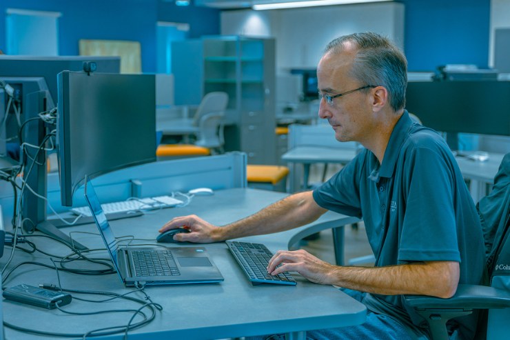 A Delta Media Group developer working at a laptop in the company's open office.