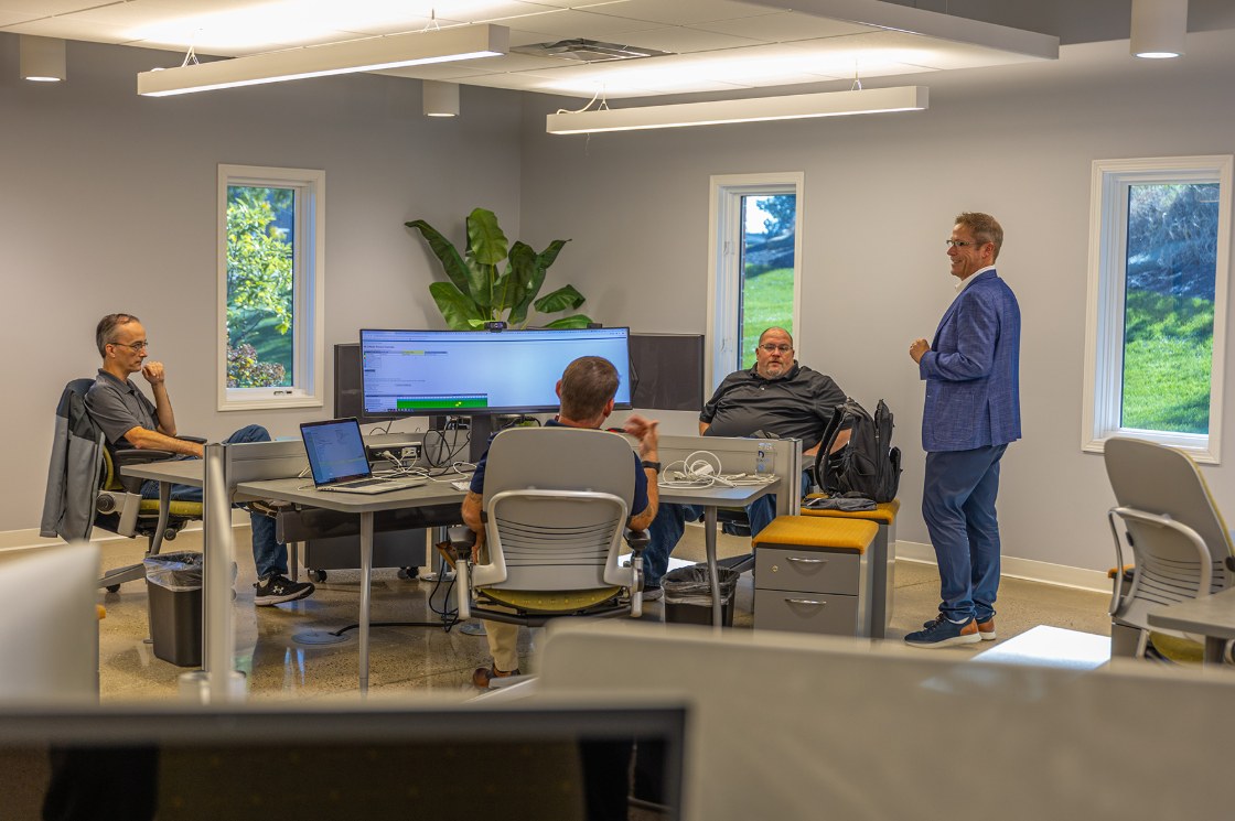 Delta Media Group team members collaborating around a desk in the company's open office.