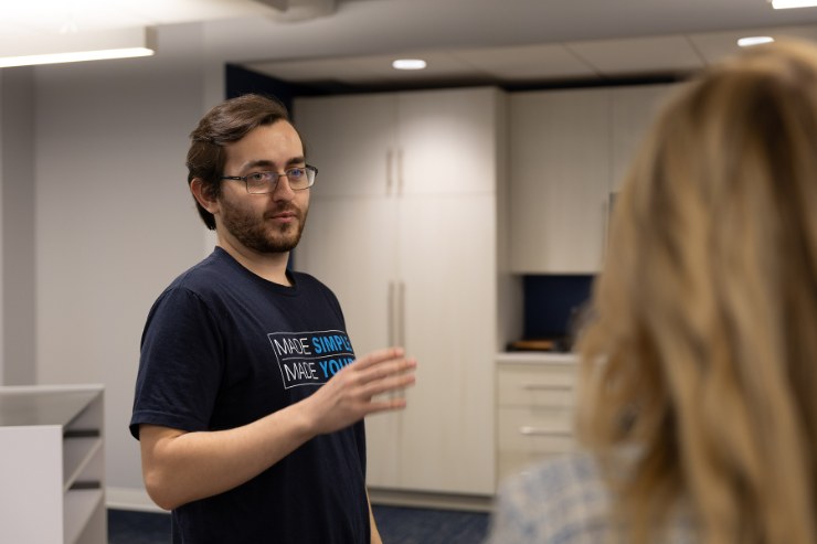 A Delta Media Group team member talking with a colleague in the office.