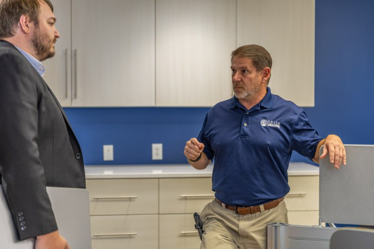 Two Delta Media Group team members in conversation in the office kitchen.