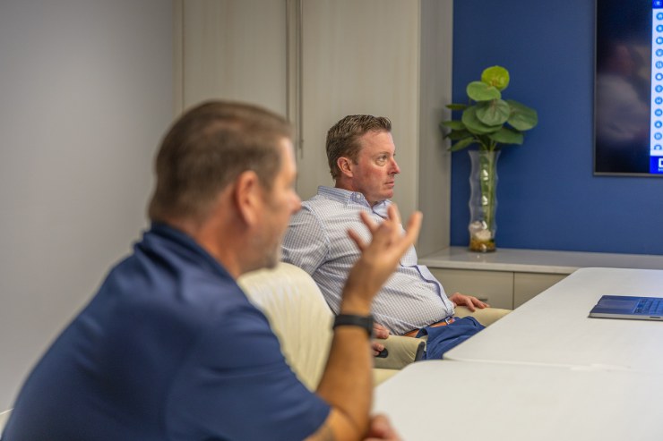 Two Delta Media Group team members in discussion in a conference room.