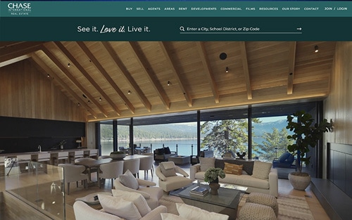 Chase International Real Estate website homepage &mdash; a luxury lakeside great room with 'See it. Love it. Live it.' over a property search bar.