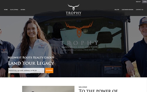 Midwest Roots Realty Group | Trophy Properties & Auction website homepage &mdash; agents beside a truck with 'Land Your Legacy' over a property search bar.