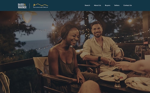 The Schumacher Group | Baird & Warner website homepage &mdash; friends sharing an evening dinner outdoors under string lights.